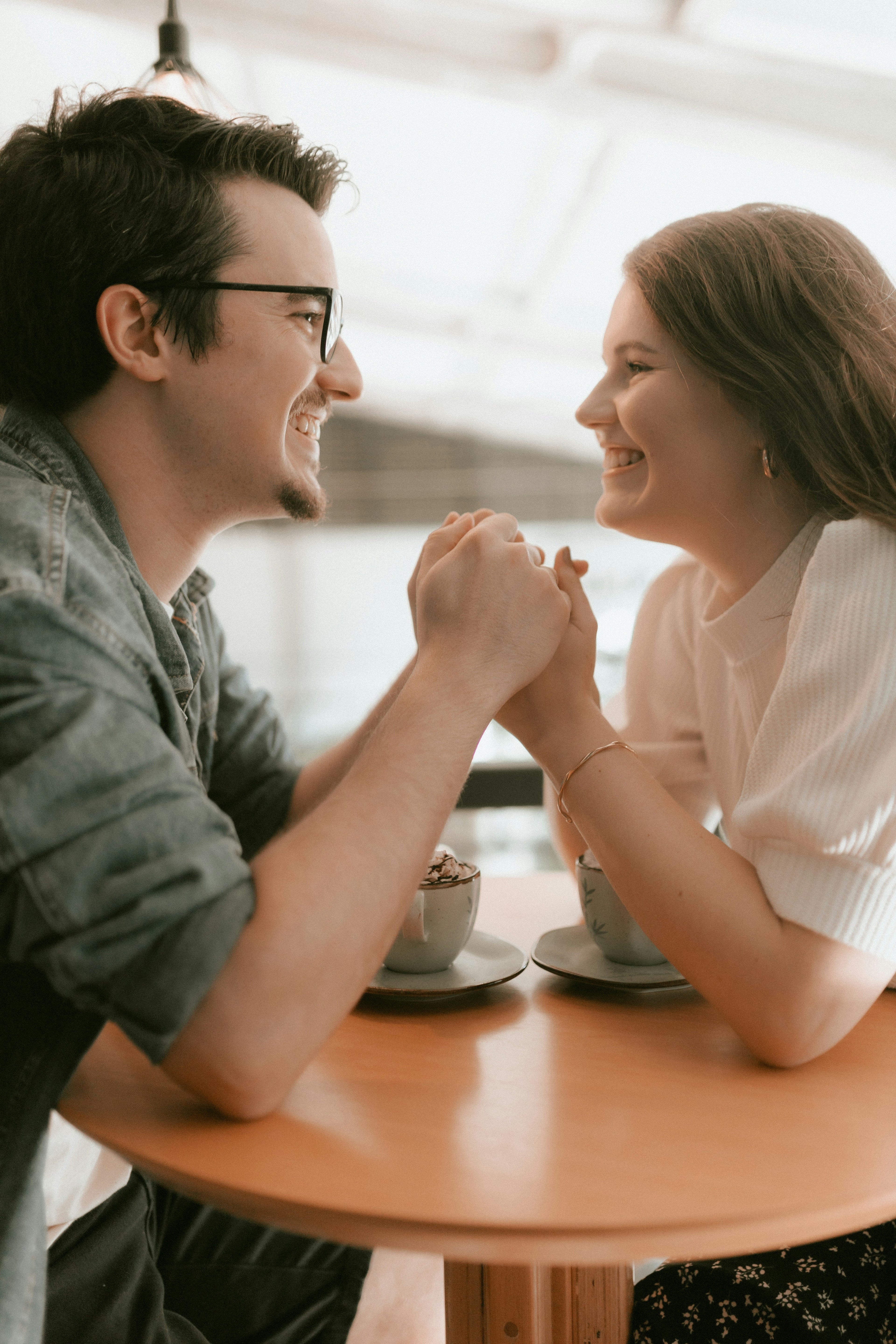 Two people laughing and connecting over coffee representing trust and emotional growth in relationships