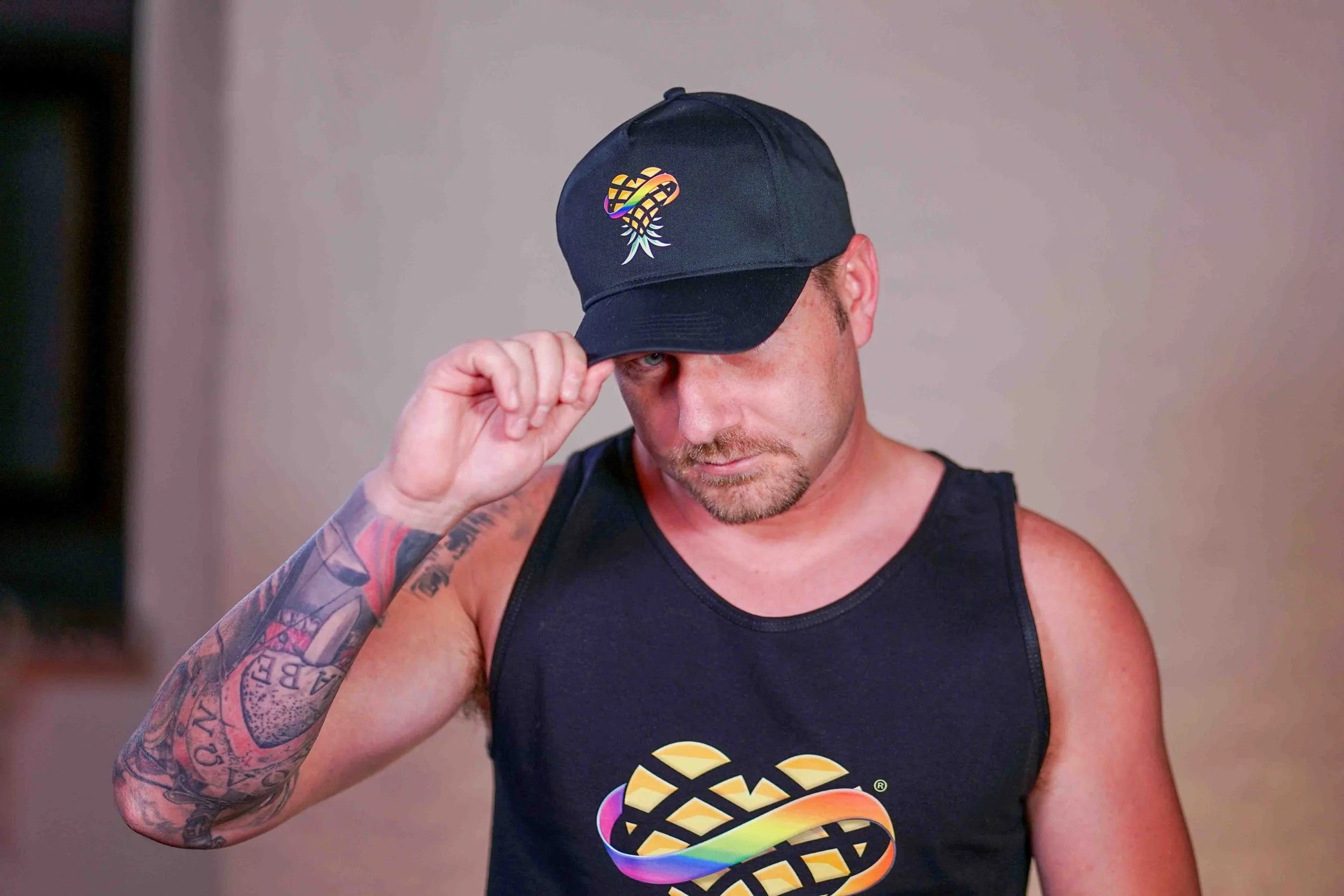 Man Wearing Upside Down Pineapple Baseball Cap and Tank Top
