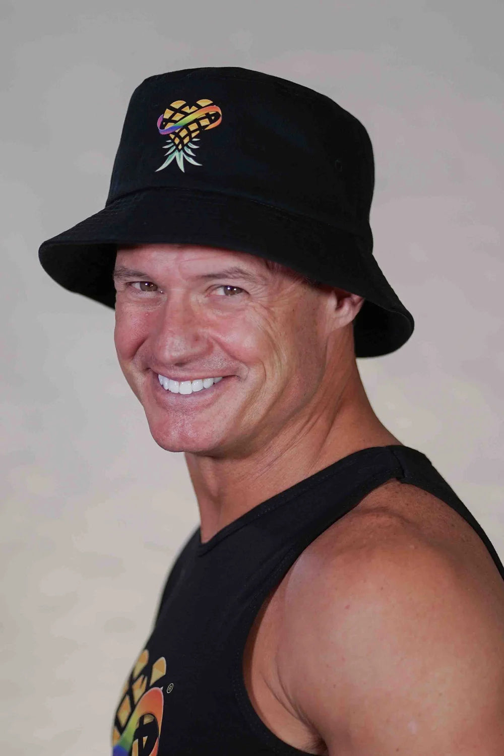 Man wearing a black bucket hat with a pineapple logo 