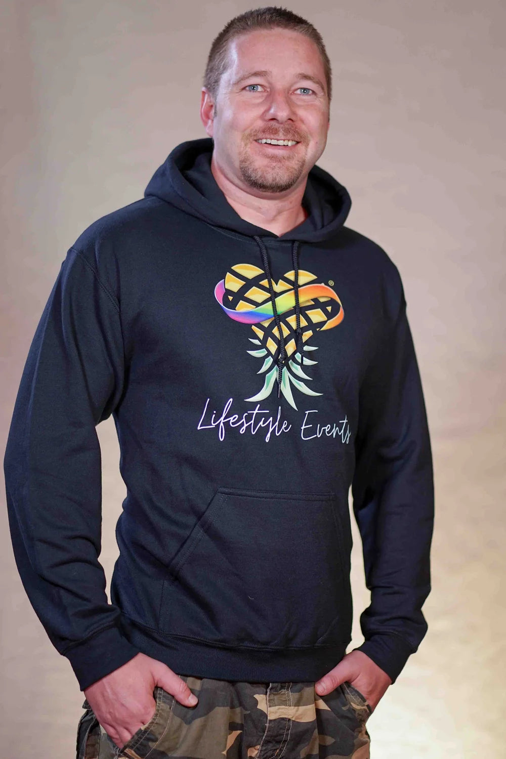 Man wearing a hoodie with a colorful design and 'Lifestyle Events' text and Upsidedown Pineapple Logo