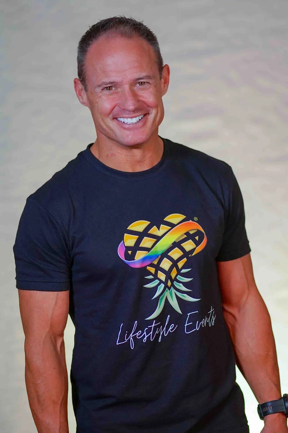 Man wearing a black t-shirt with an upside-down pineapple logo and 'Lifestyle Events' text on a plain background